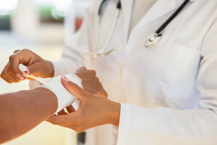 doctor wrapping a wound 
